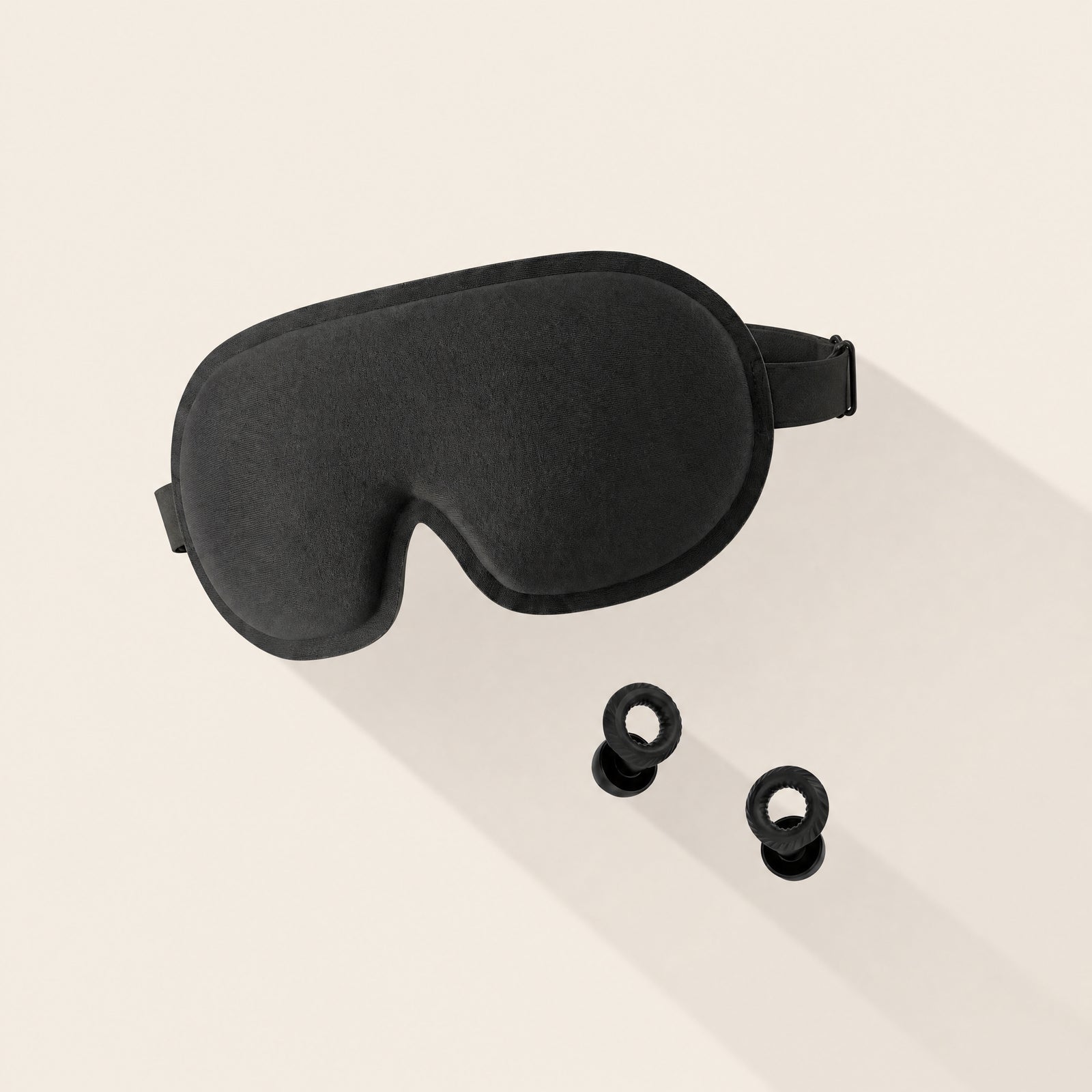 Somnia Sleep Set - Sable mask and Mute earplugs on a serene bed