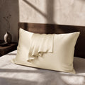 Somnia Sheen mulberry silk pillowcase in cream, draped on a styled bed